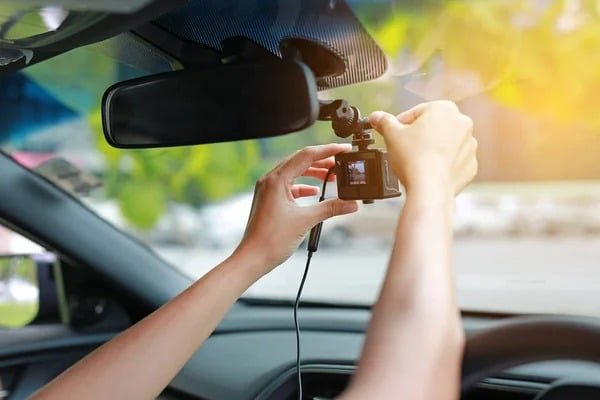 Person installing a dash cam in a vehicle for improve car security