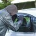 hooded thief looking through car window